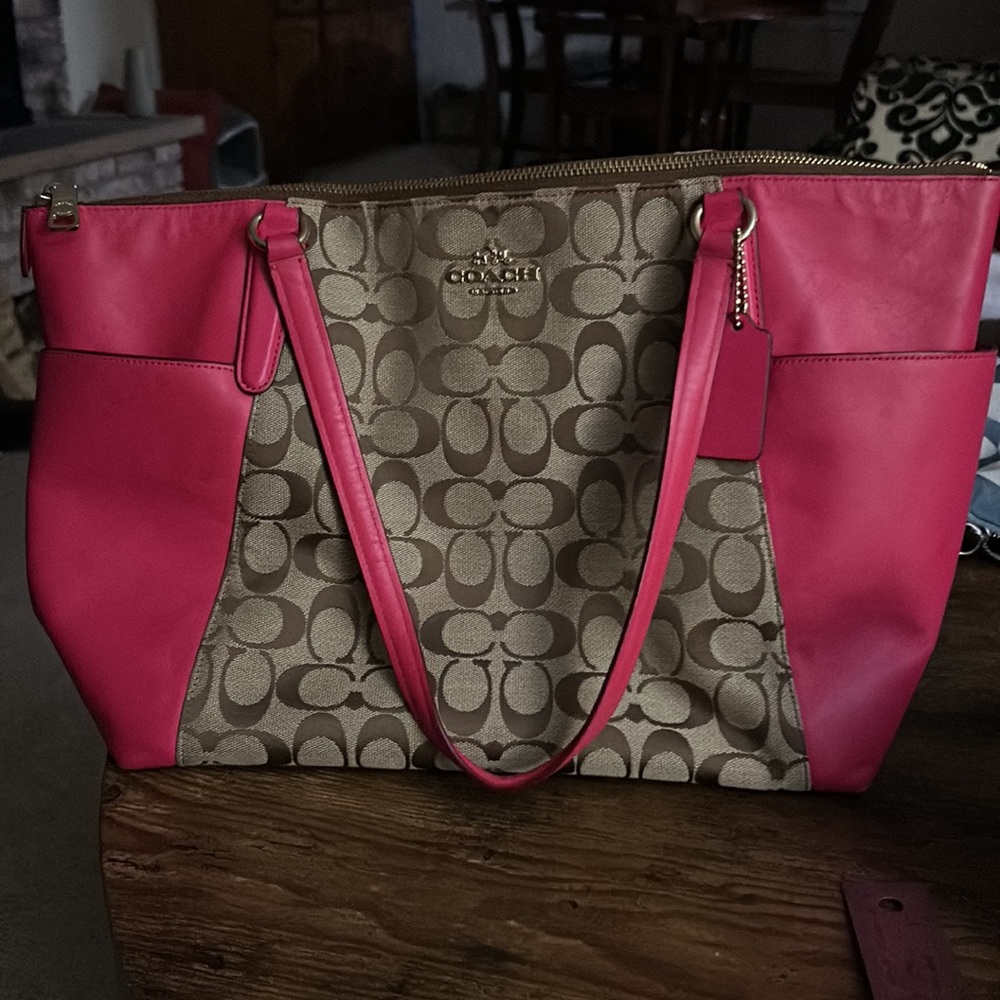 Coach Shoulder With side pockets and zip closure.  Medium pink, brown C pattern
